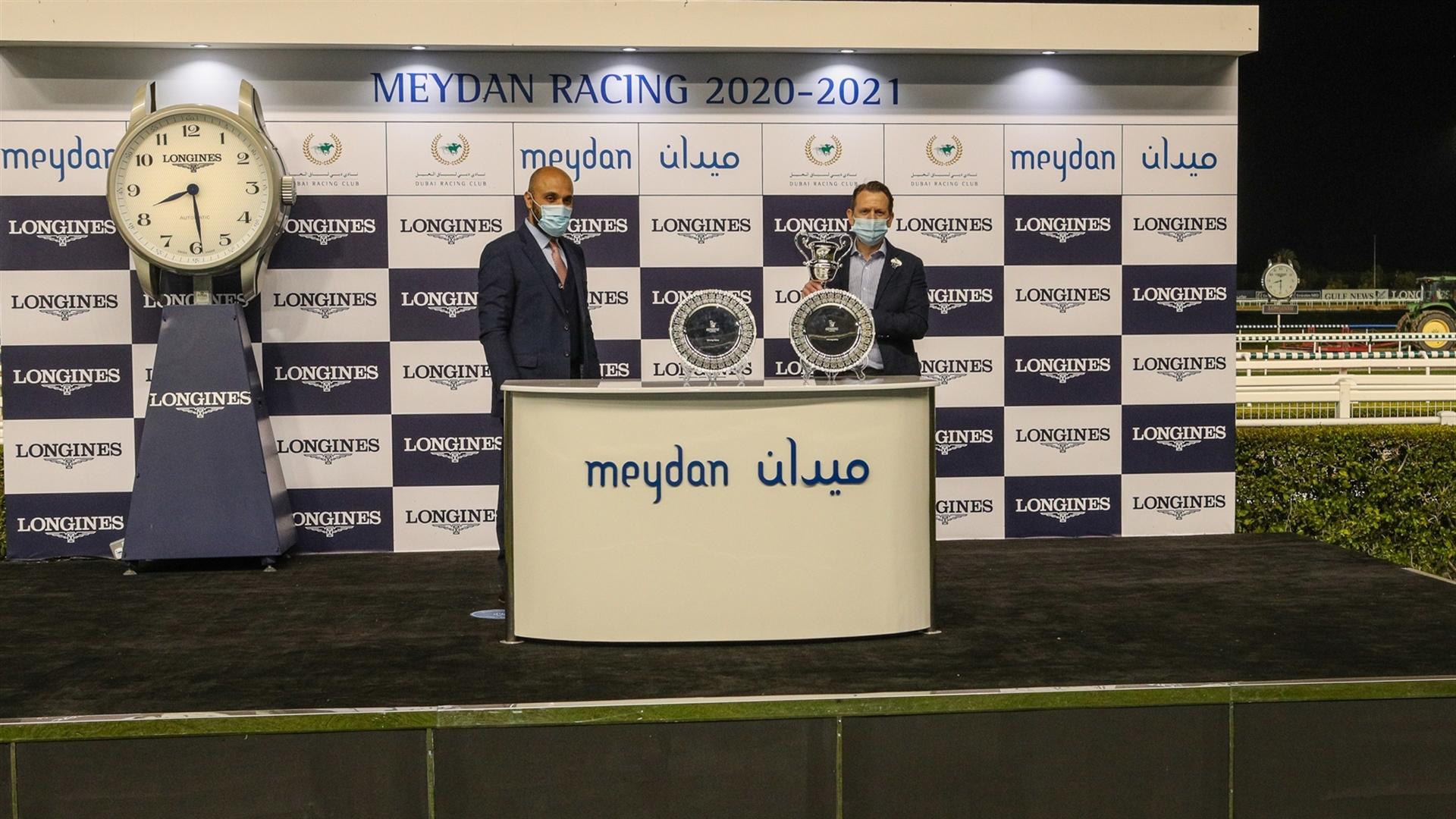 Tony Howarth accepts the owner's trophy for the UAE 1000 Guineas Trial Presented By Longines, from Mr. Patrick Aoun, Regional Brand Manager, Longines, on January 07, 2021. (Credit: Dubai Racing Club)