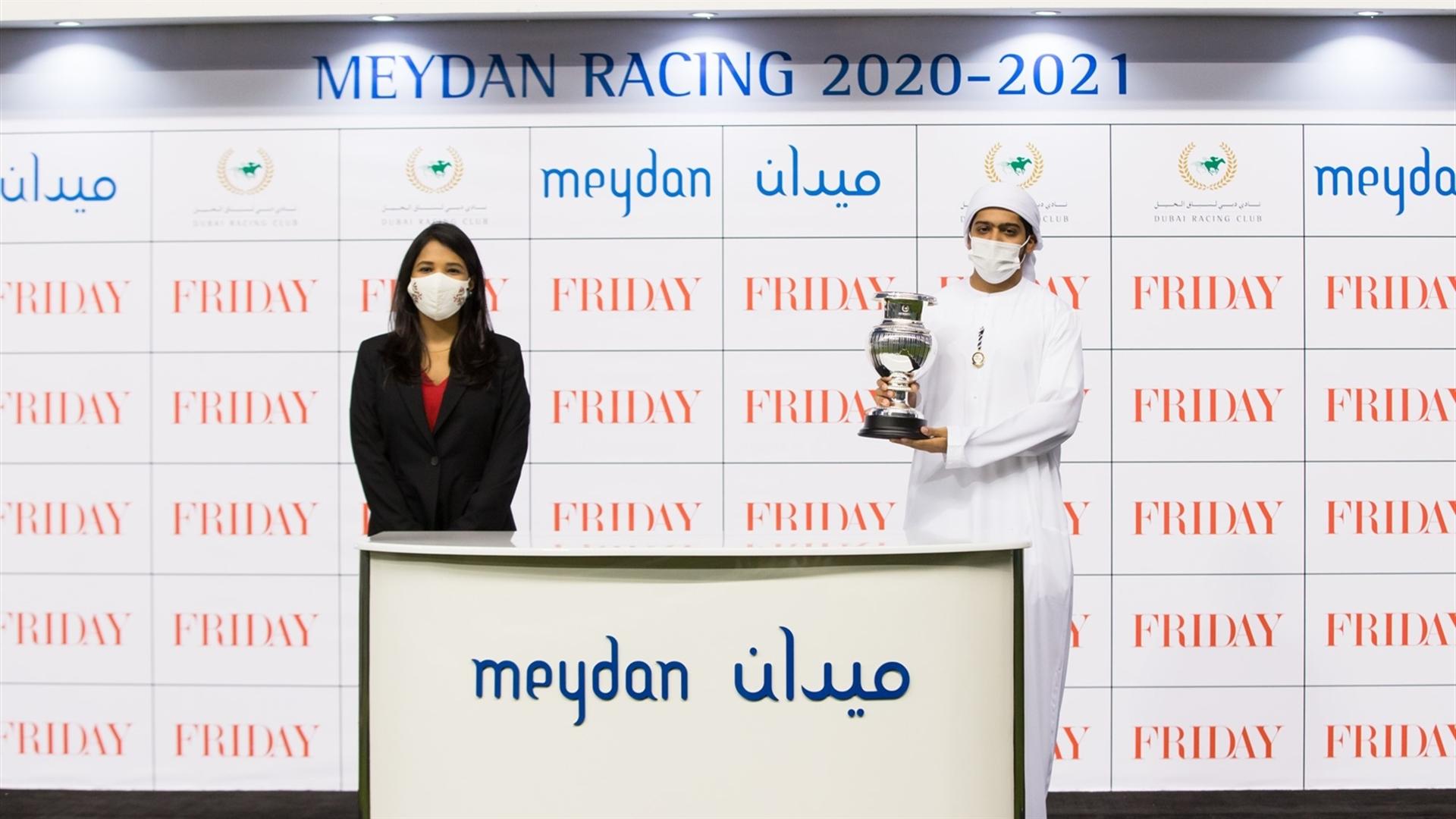 Humaid Rashid Ali Alaleeli accepts the trophy for the Friday 1800m maiden race, from Ms. Shruti More, Senior Account Group Manager, on January 30, 2021. (Credit: Erika Rasmussen//Dubai Racing Club)