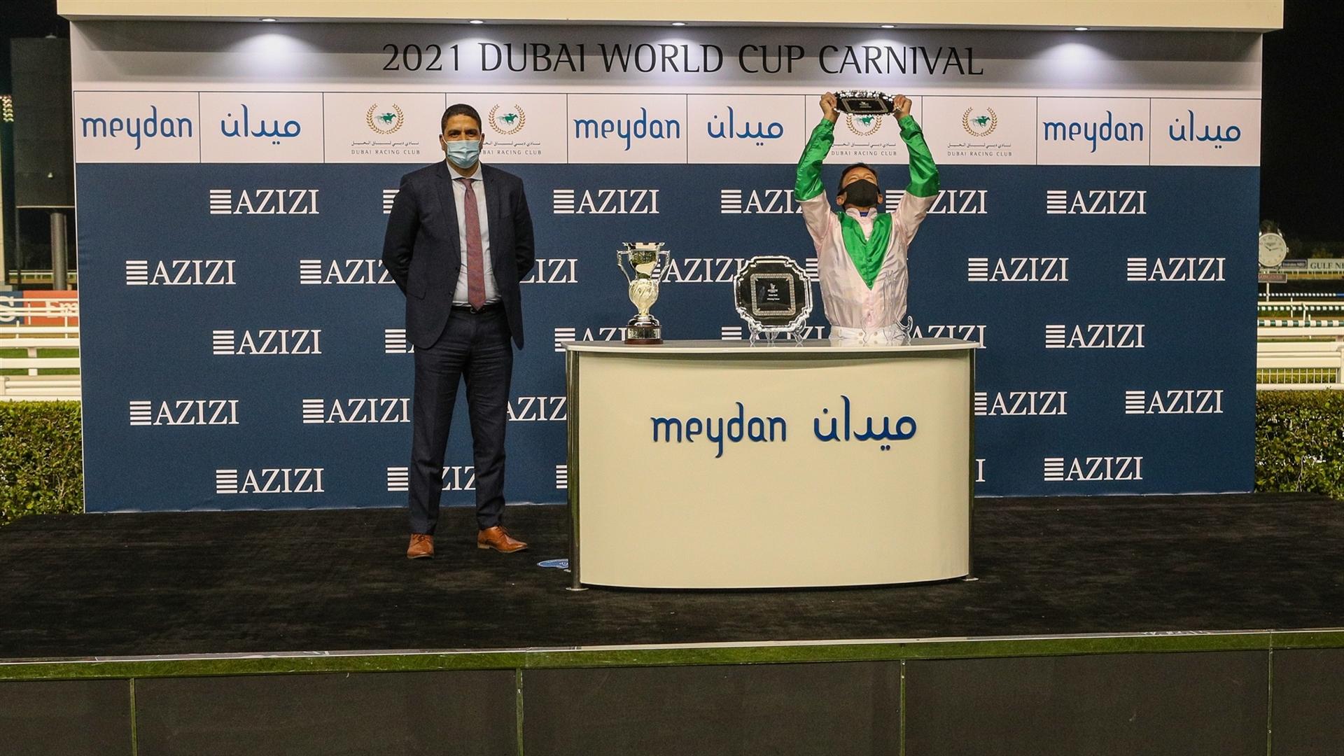 Lanfranco Dettori accepts the trophy for the Dubai Dash Sponsored By Aura By Azizi from Mr. Nashat Mustafa Helal, CFO, Azizi Developments, on January 21, 2021. (Credit: DRC)