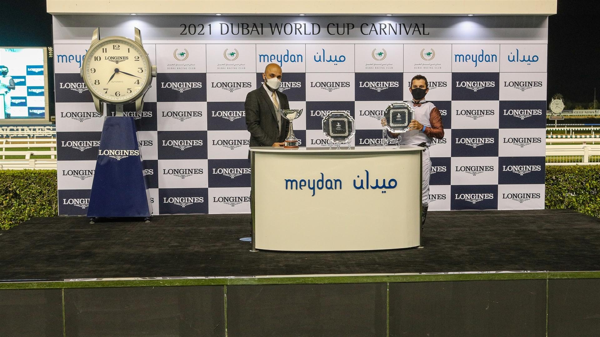 Winning jockey Vagner Leal accepts the trophy for the Al Bastakiya Trial Presented By Longines, from Mr. Patrick Aoun, Regional Brand Manager Longines, on January 28, 2021. (Credit:DRC)