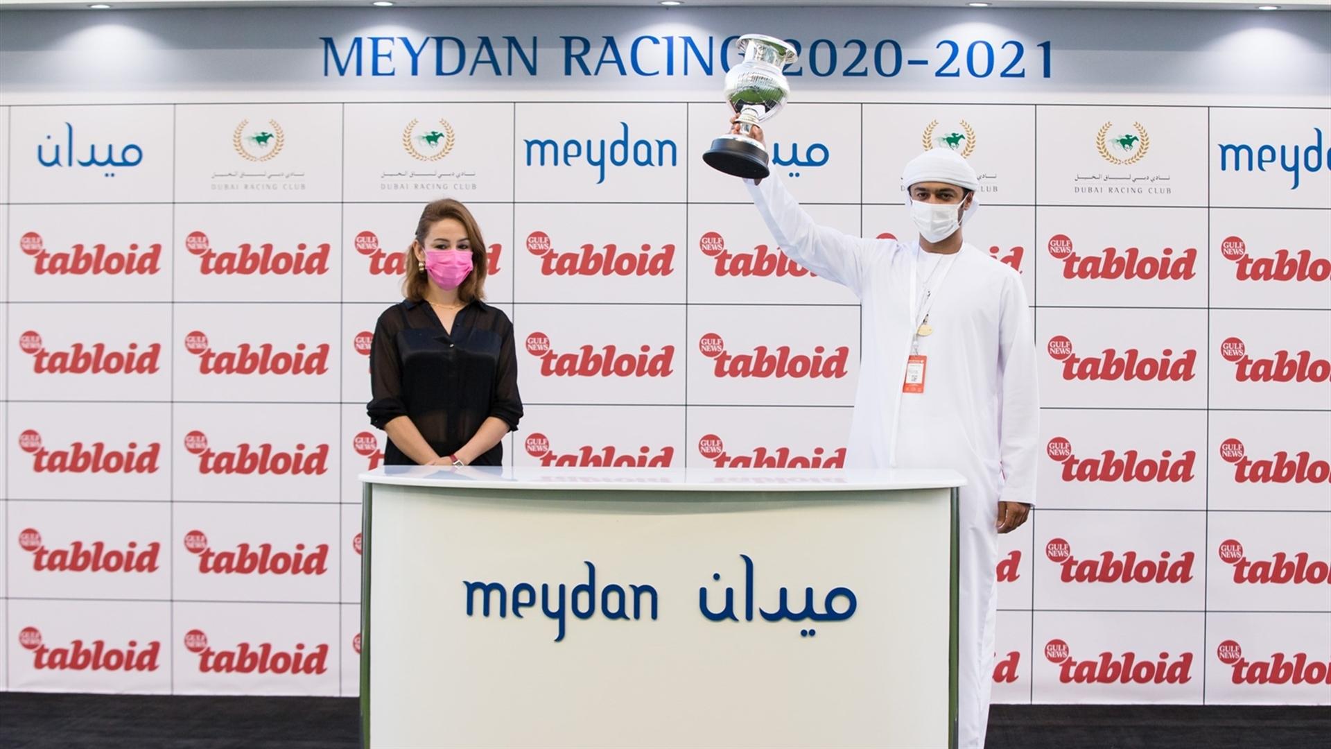 Salman Alsabri accepts the trophy on behalf of the owner for the Tabloid, from Ms. Mehak Taneja, Relationship Manager, Gulf News, on January 30, 2021. (Credit: Erika Rasmussen //Dubai Racing Club)