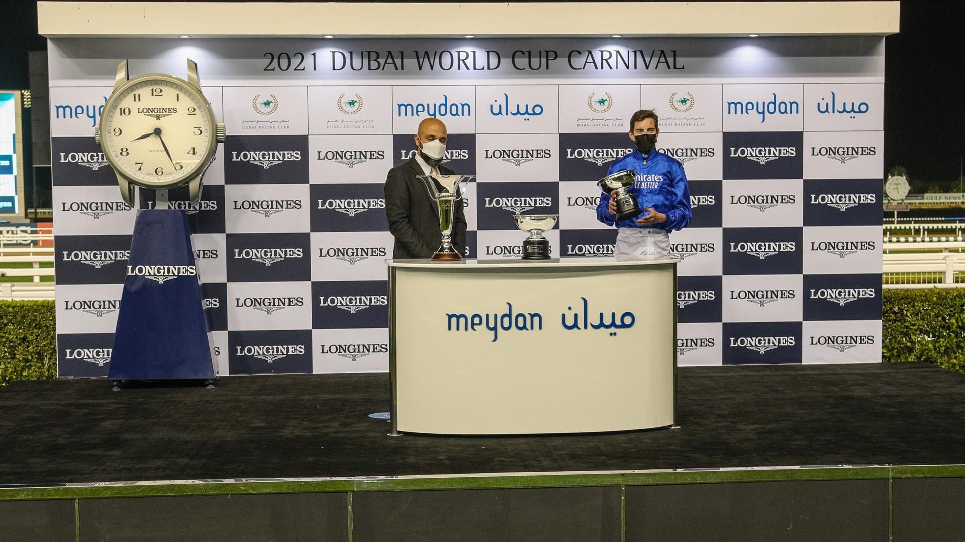 Derek Poupard accepts the trophy for the 1600m, Cape Verde Presented by Longines, from Mr. Patrick Aoun, Regional Brand Manager Longines on January 28, 2021. (Credit: Dubai Racing Club)