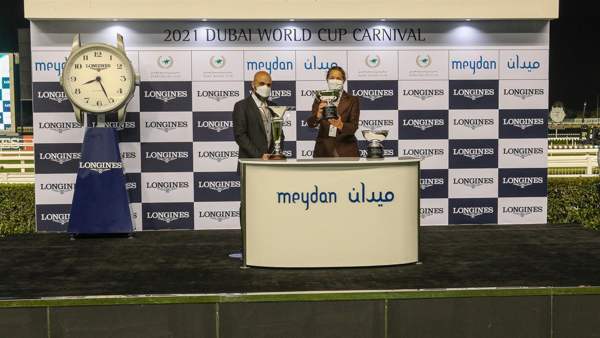 Sophie Chretien accepts the trophy for the 1600m, Cape Verde Presented by Longines, from Mr. Patrick Aoun, Regional Brand Manager Longines on January 28, 2021. (Credit: Dubai Racing Club)