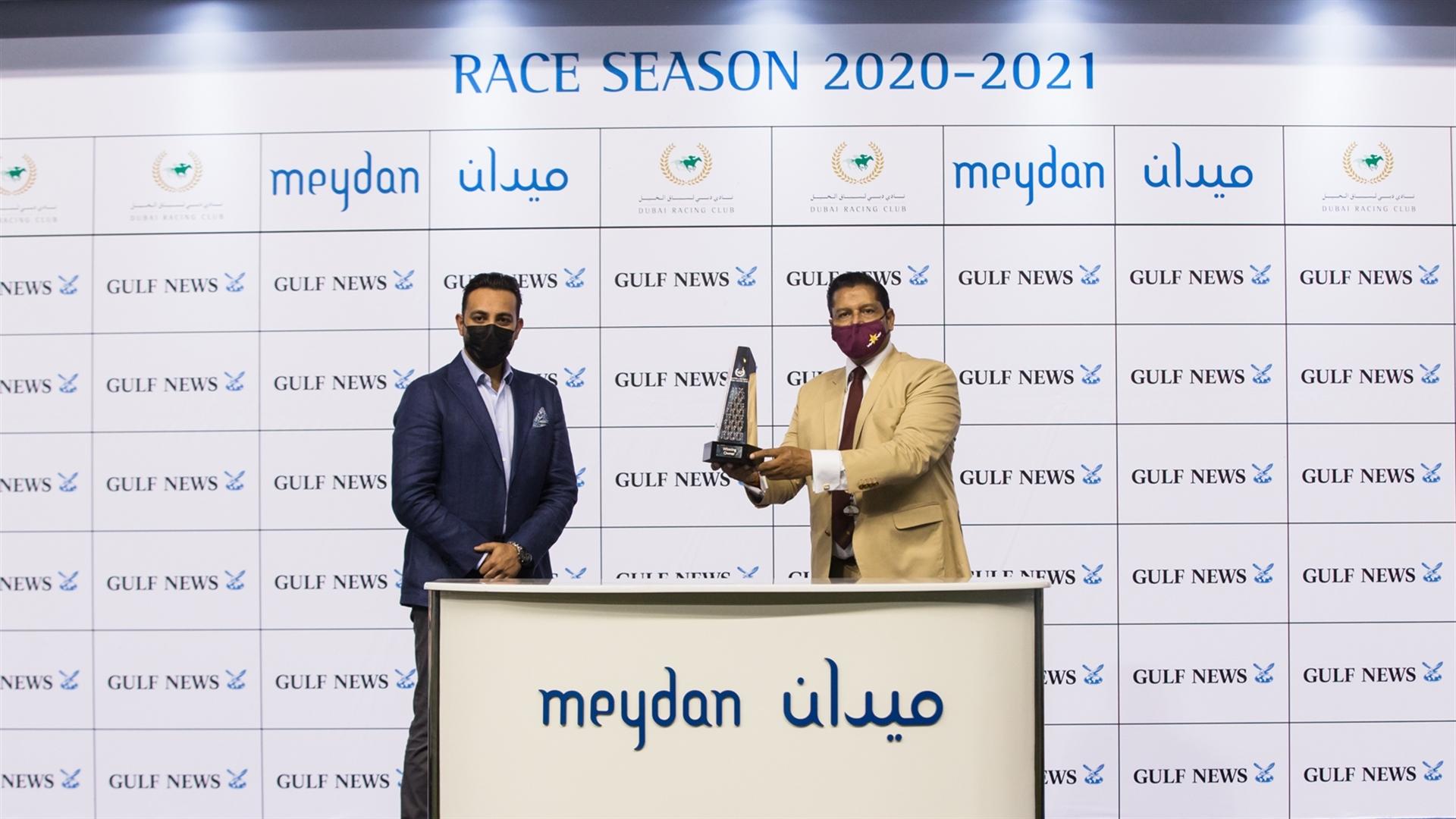 Winning trainer Satish Seemar accepts the trophy for the Gulf News Handicap Sponsored By Gulf News, from Mr. Rizvi Riaz, Online Sales Manager, Gulf News on April 8, 2021.(Credit: DRC//Erika Rasmussen)