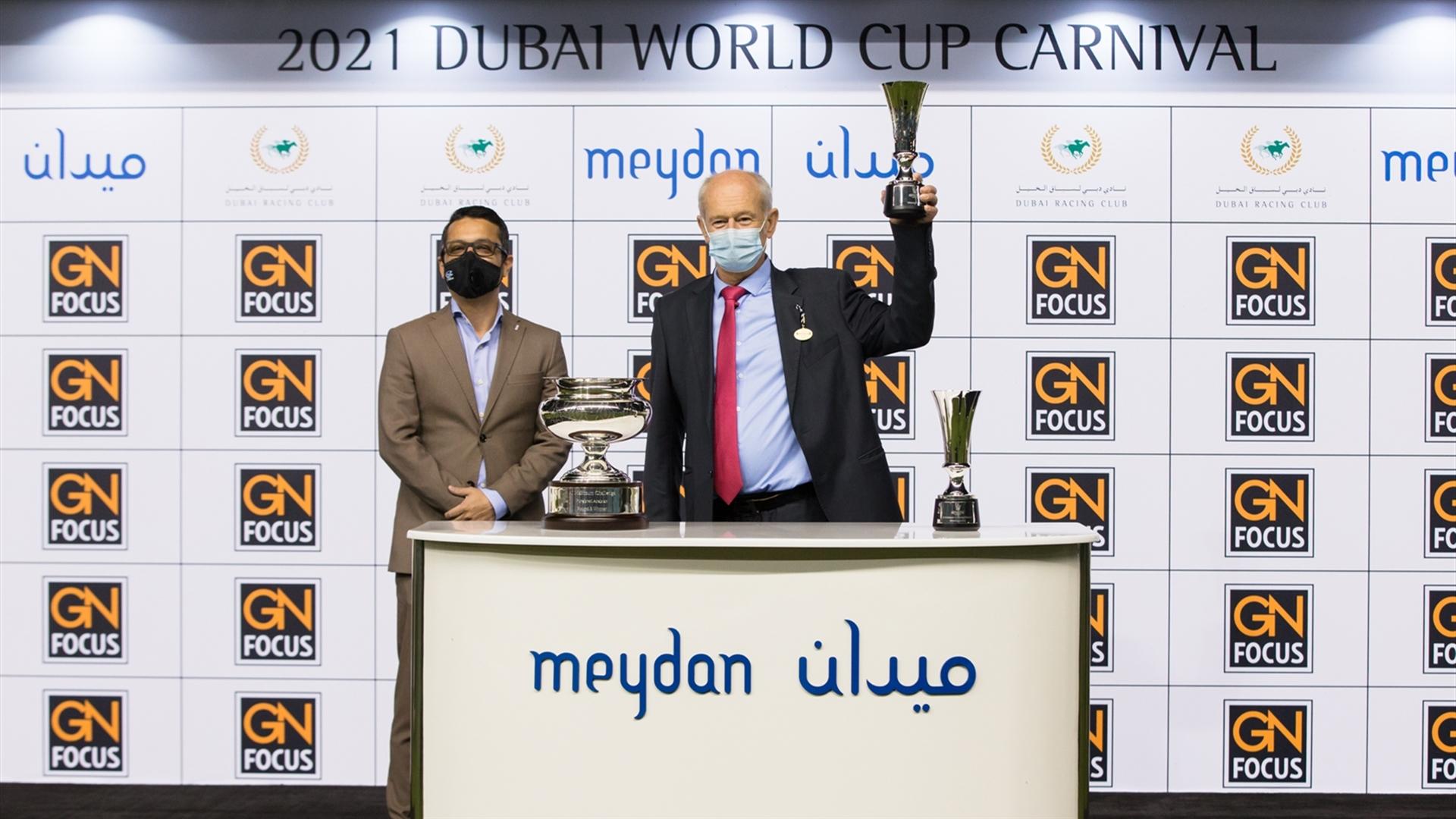 Jean-Claude Pecout accepts the trophy for the Al Maktoum Challenge R3 Sponsored by gnfocus from Sundar Ghosh, Head of Sales-Supp. & Contract Publishing on Feb 25,2021.(Credit:Erika Rasmussen/DRC)