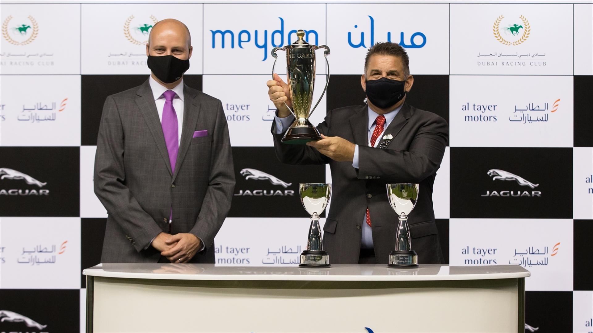 Doug Watson accepts the trophies for the UAE Oaks Sponsored By New Jaguar F-Type from Benjamin Trespe, Brand Director - Jaguar Land Rover MENA on February 18, 2021. (Credit: Erika Rasmussen//DRC)