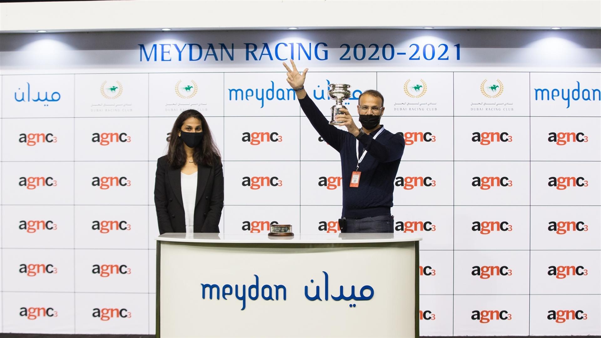 Elbashir Salem Elhrari accepts the trophy for the Agnc3, from Ms. Priya Mathew, Senior Editor, Gulf News, on January 30, 2021. (Credit: Dubai Racing Club // Erika Rasmussen)
