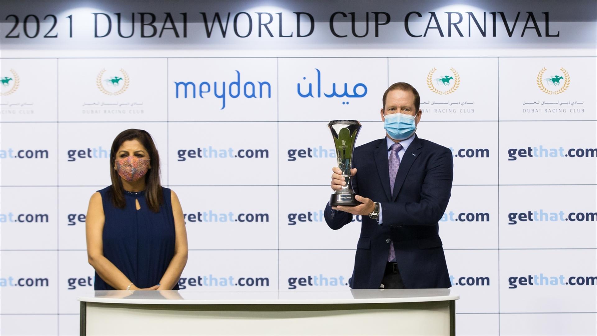 Rod Daniel accepts the trophy for the getthat.com, 1800m Handicap from Puja Wadhwa, Sales Manager - Classified on February 25, 2021. (Credit: Erika Rasmussen//Dubai Racing Club)
