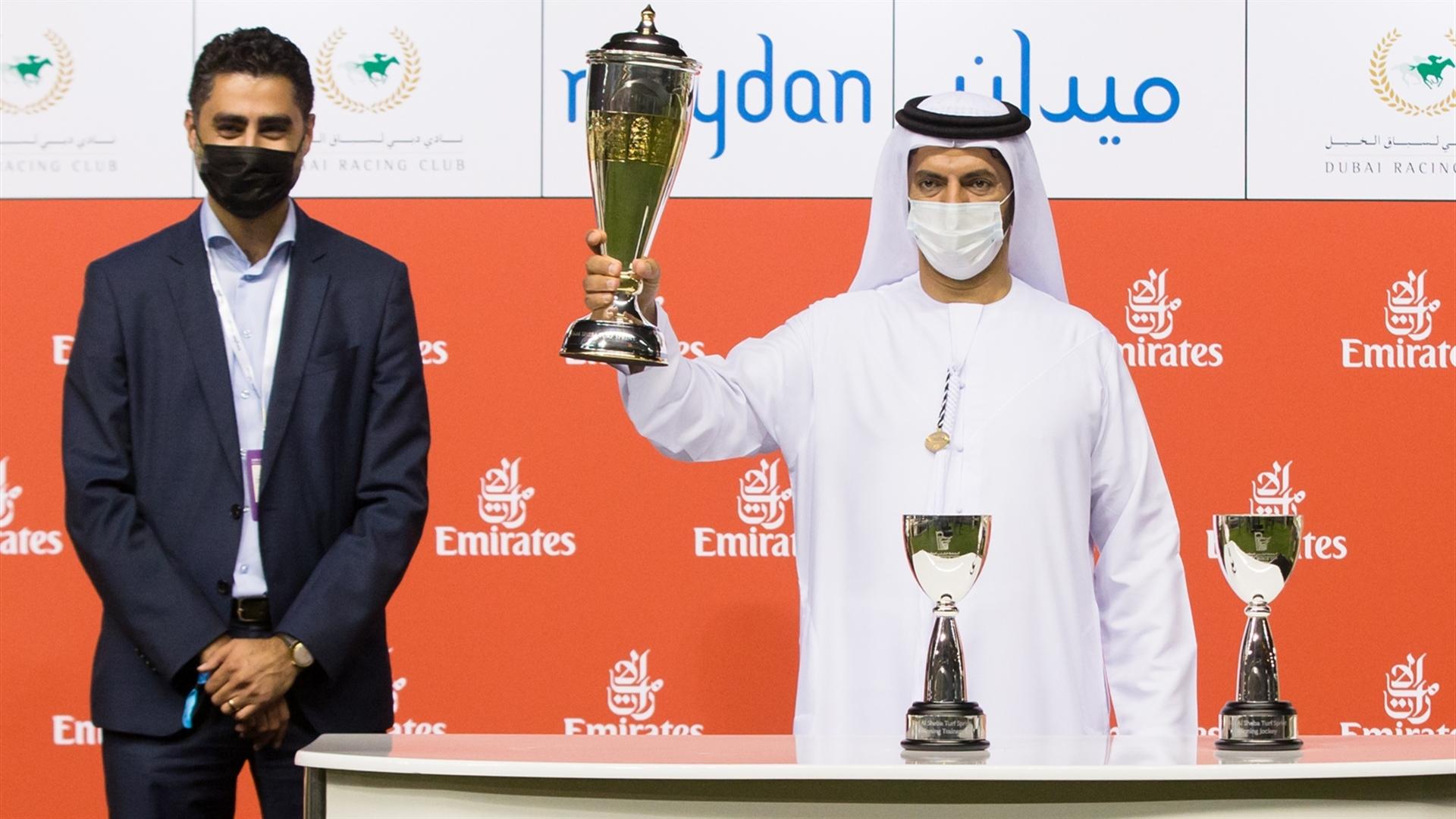 Saeed Bin Suroor accepts the trophy for the Nad Al Sheba Turf Sprint Sponsored By emirates.com from Samer Alhaider, Senior Manager E-commerce Mobile on March 06, 2021. (Credit: Erika Rasmussen//DRC)