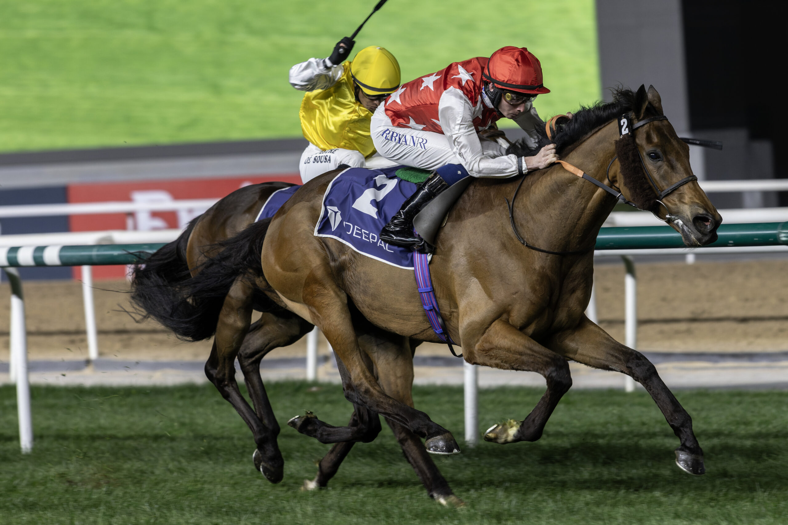 Two horses racing on a track.