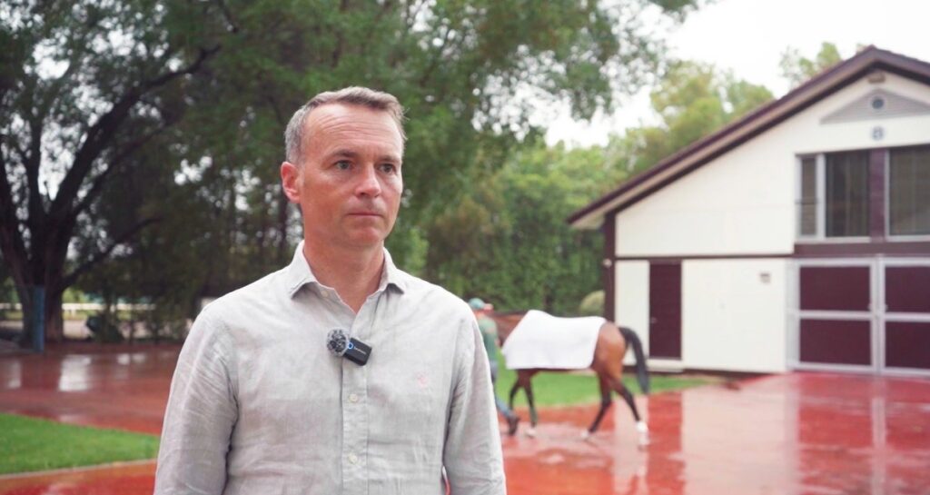 Man standing near a horse stable